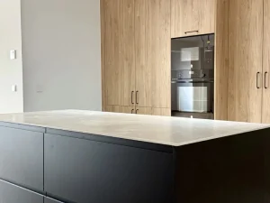 cocina reformada con isla negra y blanca